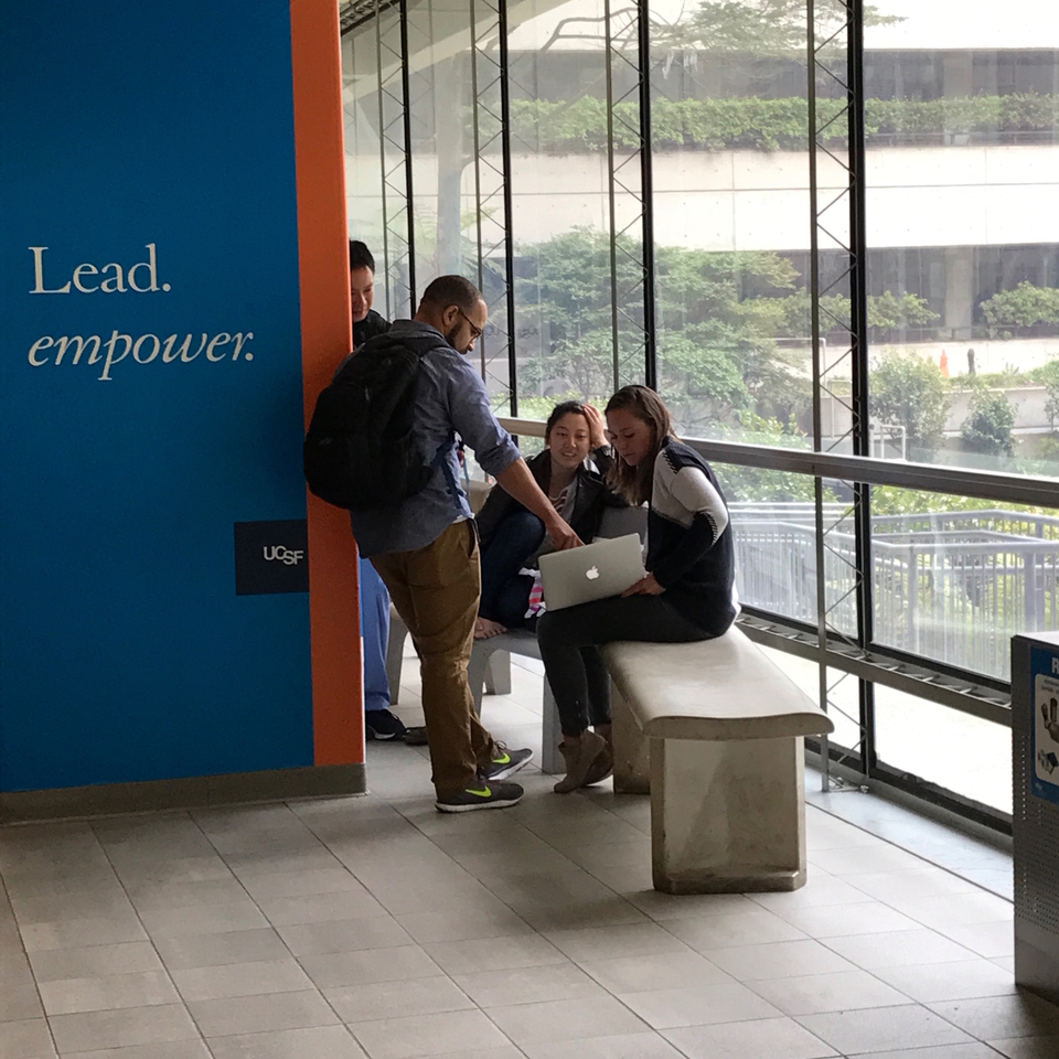 Three people looking at a laptop