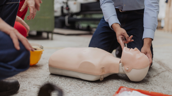 Someone teaching someone else how to do perform an exam on a dummy