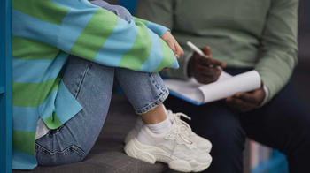 Teenager sitting down talking to a therapist