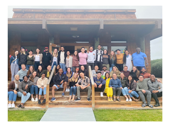 Large group posing for a photo outside of a building