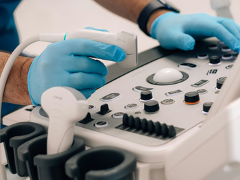 A technician holds his hand over an ultrasound machine