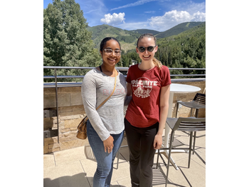 two people posing for a photo outside