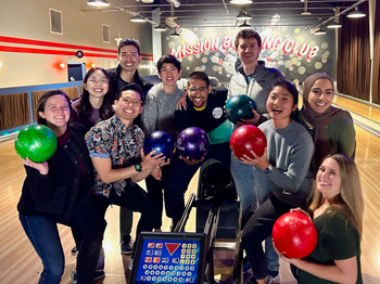 group of people posing for a photo at a bowling alley