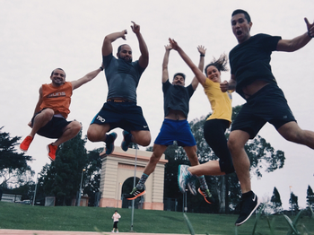 five people jumping on a track