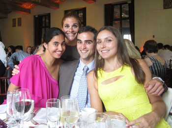 4 people pose for a photo in front of drinkware